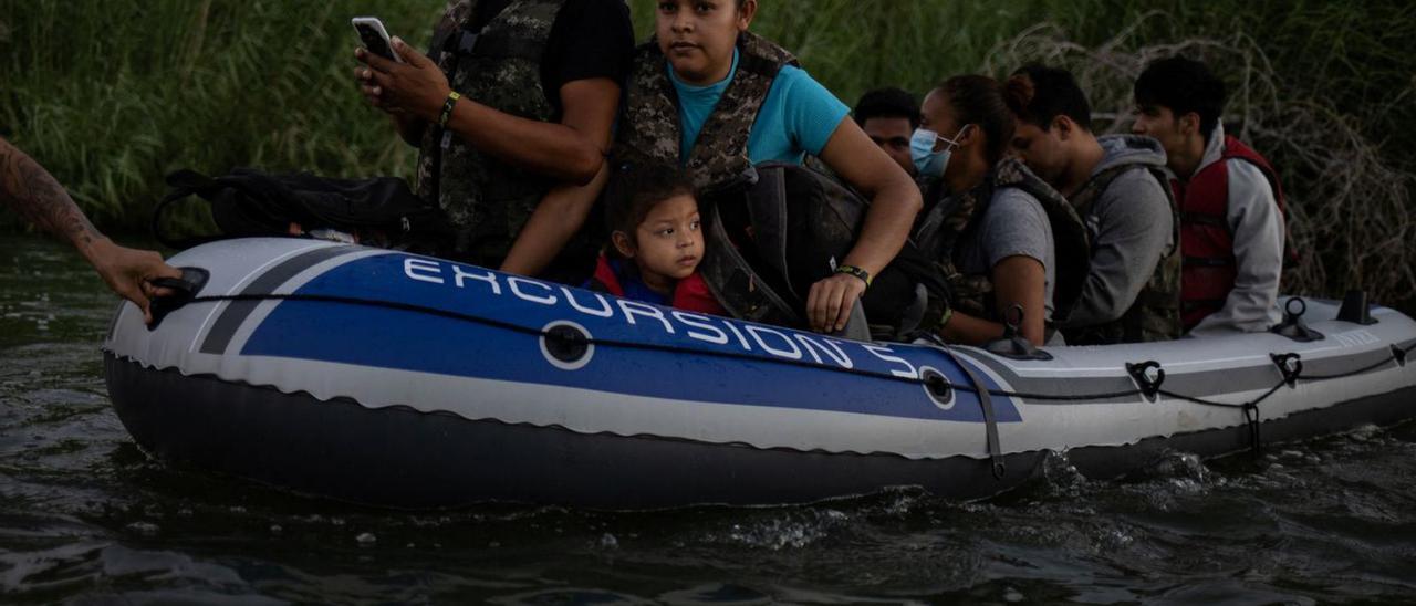 Un grup de persones intenten creuar el Río Bravo en una embarcació pneumàtica. | REUTERS