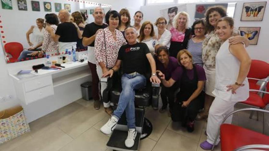 Trabajadores y usuarios del Hogar del Pensionista con Ismael Sarabia, sentado en su peluquería.