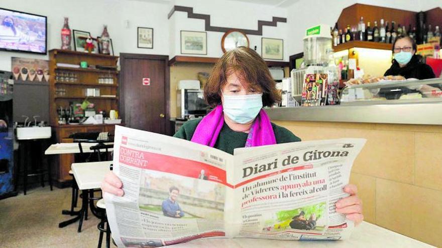 Una lectora llegint el Diari de
 Girona en un bar.  aniol resclosa