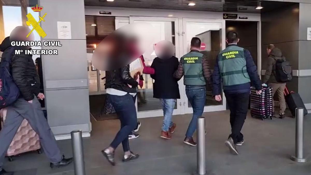 Agentes de la Guardia Civil y de la Politia Romana embarcan al detenido en el aeropuerto de Bucarest.