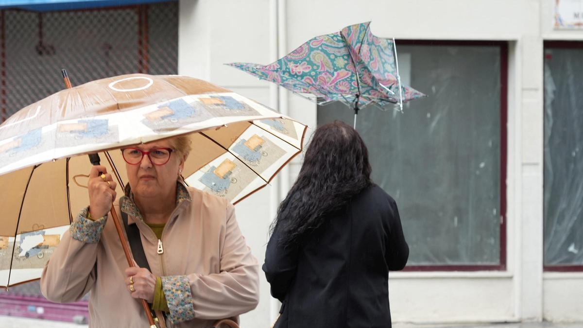 Dos mujeres se protegen del viento y la lluvia, en una imagen de archivo.