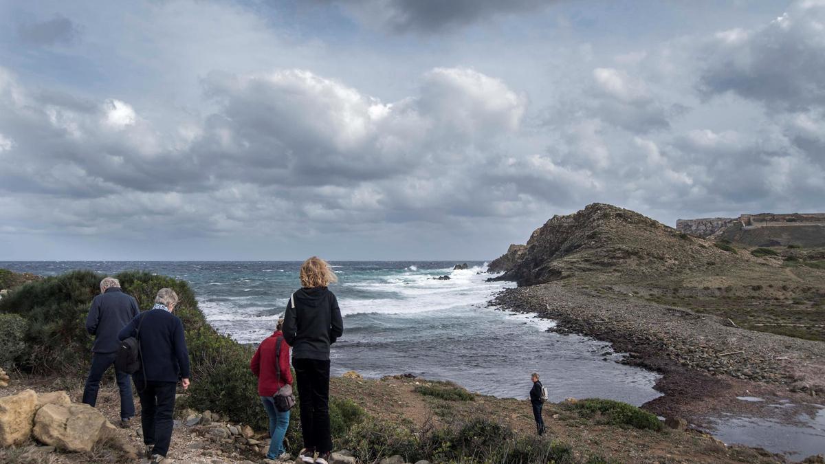 Personas junto a los acantilados de Menorca.