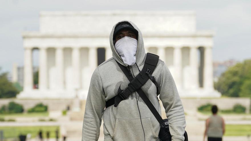 Un hombre con mascarilla frente al monumento a Lincoln en Washington.