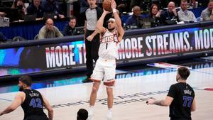 Devin Booker, de los Phoenix Suns, ante los jugadores de los Dallas Mavericks Maxi Kleber, Tim Hardaway Jr. y Luka Doncic