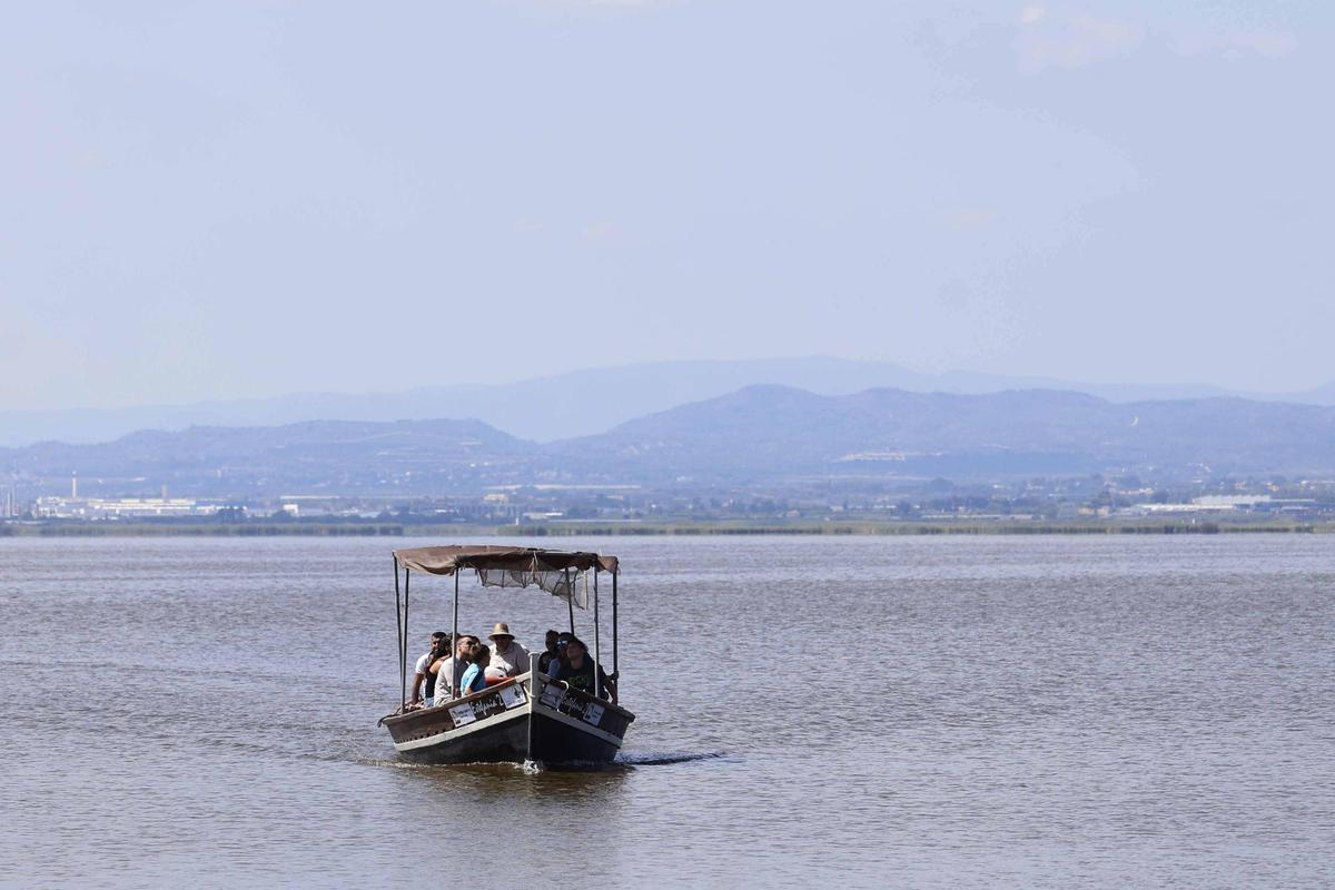 Una barca con turistas navegando por el lago de l'Albufera.