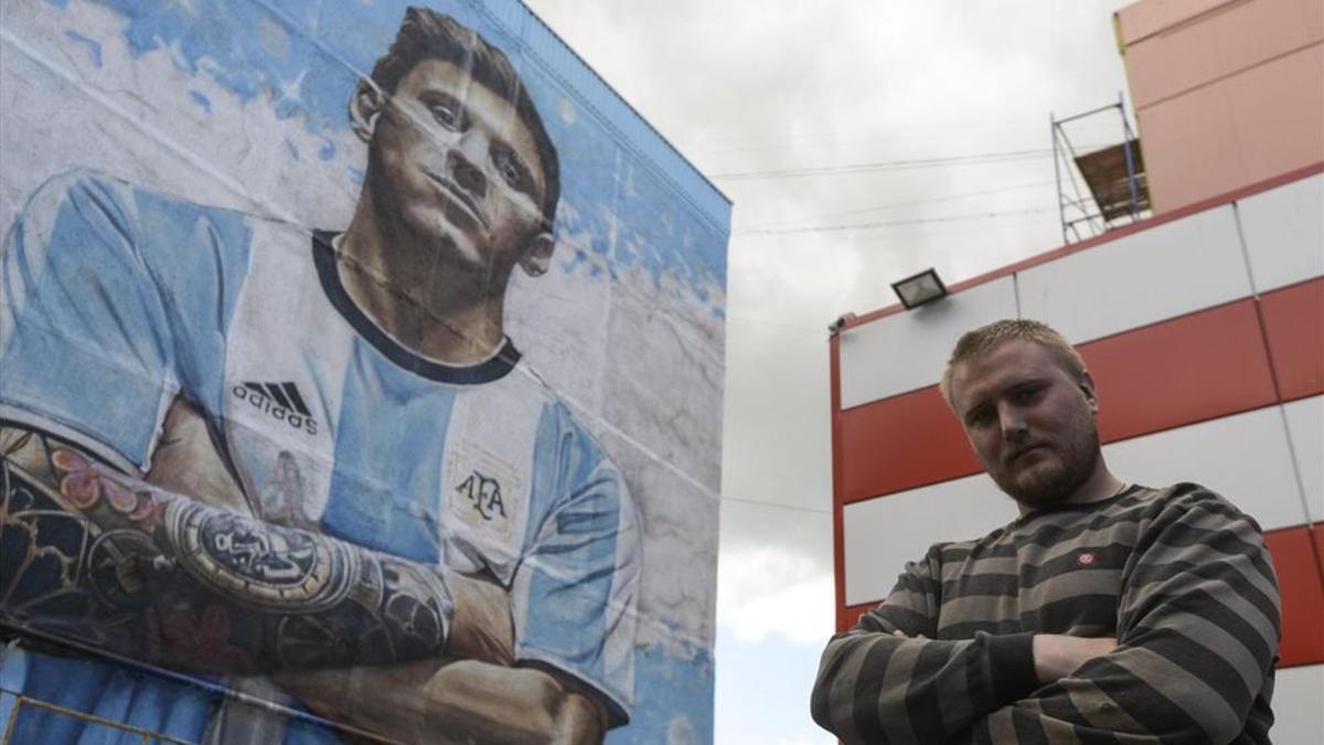 El artista callejero Sergey Erofeev junto al impresionante mural de Leo Messi