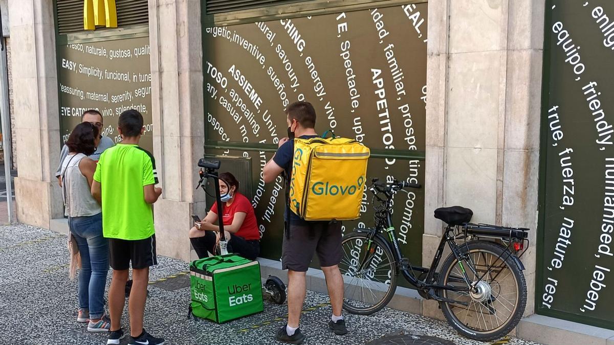 Varios ‘riders’ esperando a las puertas de un establecimiento, en el Coso. | ANDREEA VORNICU