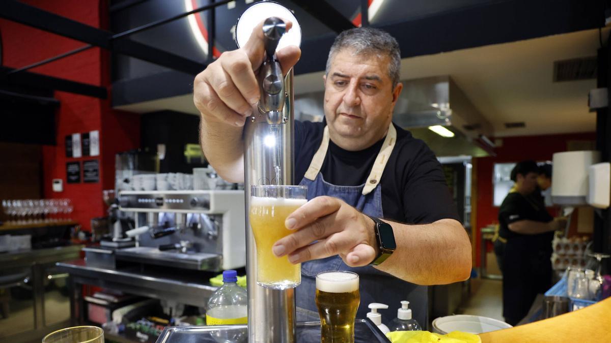 Un cambrer serveix un cervesa