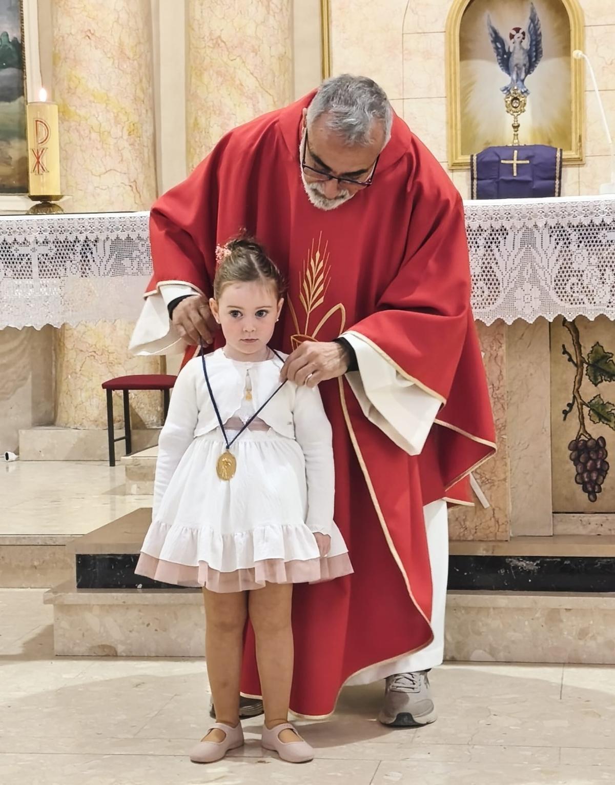 La niña Vera Ibáñez, Angelet de la Corda 2026 de Alfarrasí, tras ser bendecida por el párroco.
