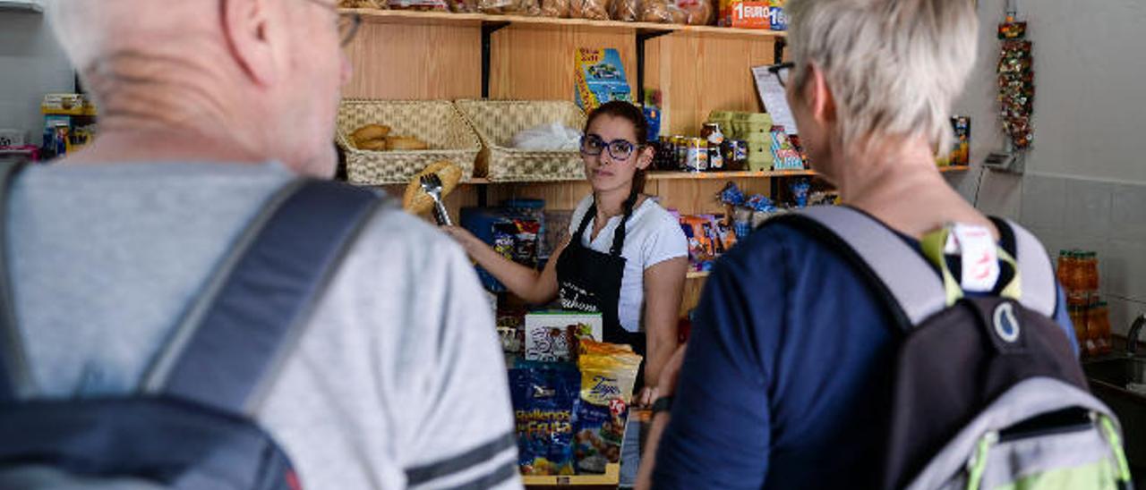 Yanira Mendoza atiende a dos extranjeros.