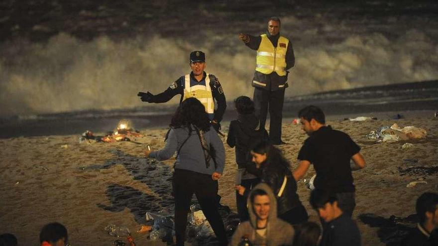 Policías locales ordenan a unos jóvenes que salgan de la playa en la madrugada de la noche de San Juan de 2013.