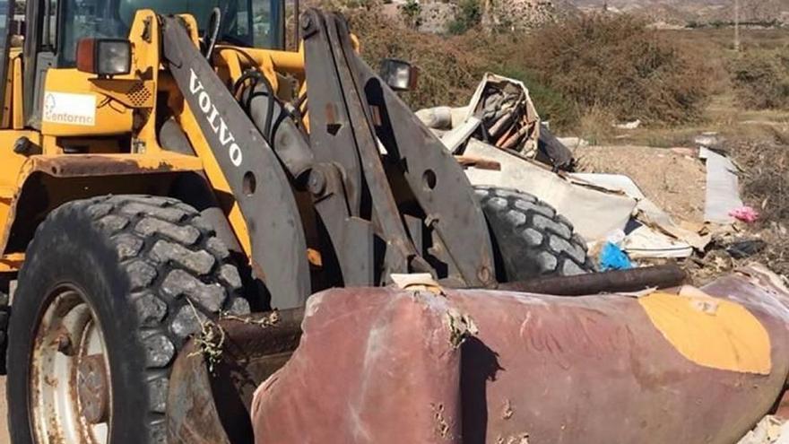 Una excavadora recoge los residuos de un solar a las afueras de Águilas.