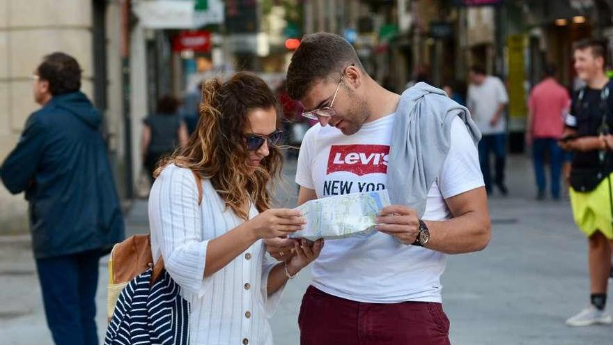 Dos turistas consultan un plano de Pontevedra. // Rafa Vázquez