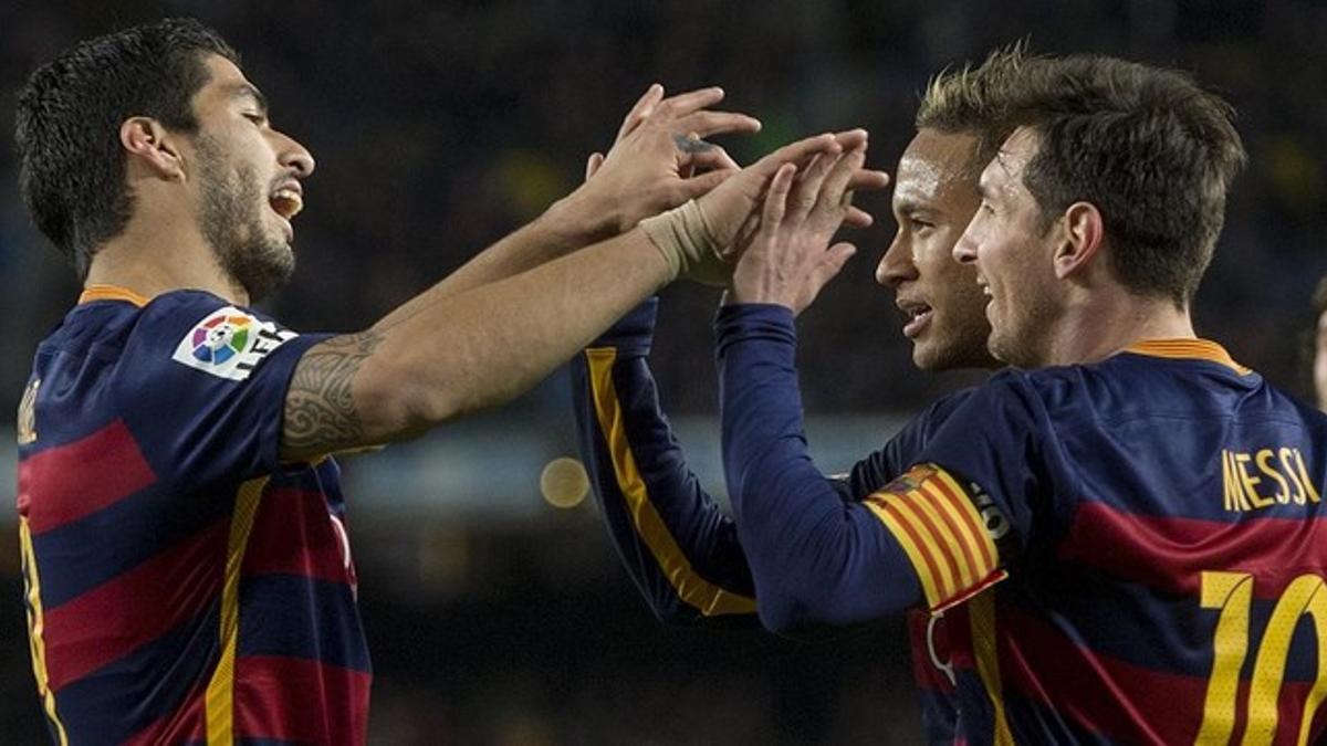 Suárez y Neymar felicitan a Messi tras su tercer gol al Valencia.