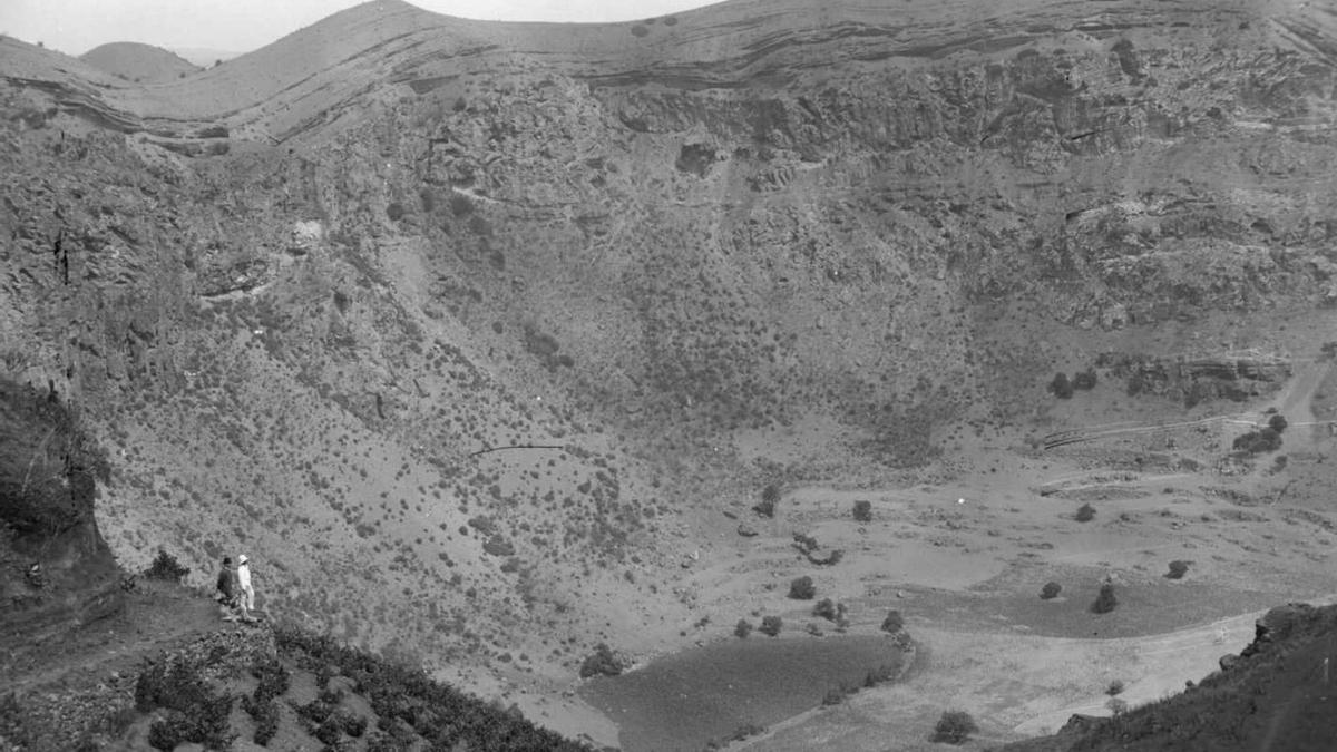 Dos turistas acompañados por un policía municipal observan el fondo de la Caldera de Bandama. | | FEDAC