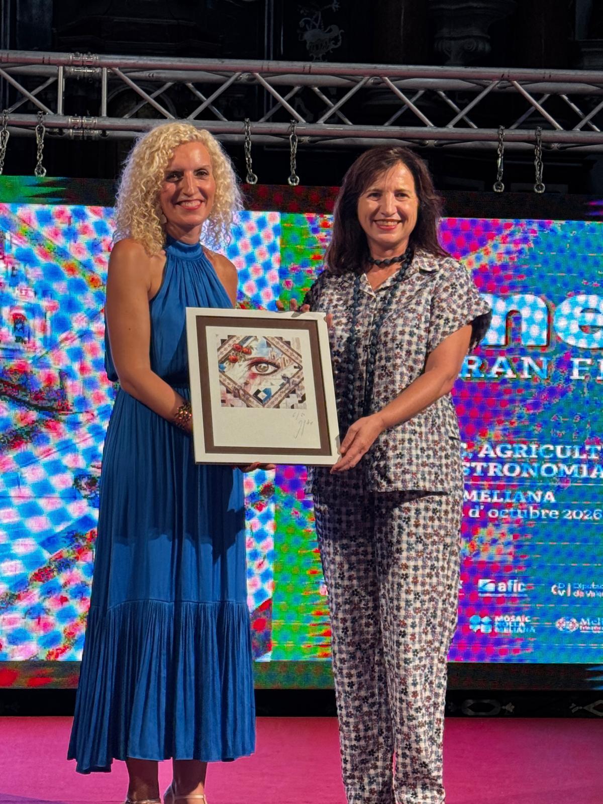 Trini MOntañana le regala a la directora General de Patrimonio, Marta Alonso, una serigrafía con la obra del cartel.