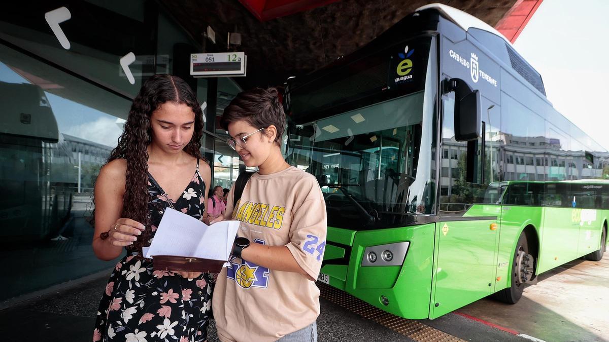Lucía, a la izquierda, y Nayara consultan el documento con las 178 líneas de Titsa en el Intercambiador de La Laguna