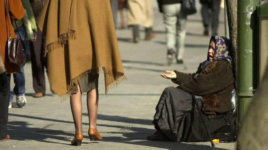 Una mujer pide limosna en una de las calles de la ciudad.