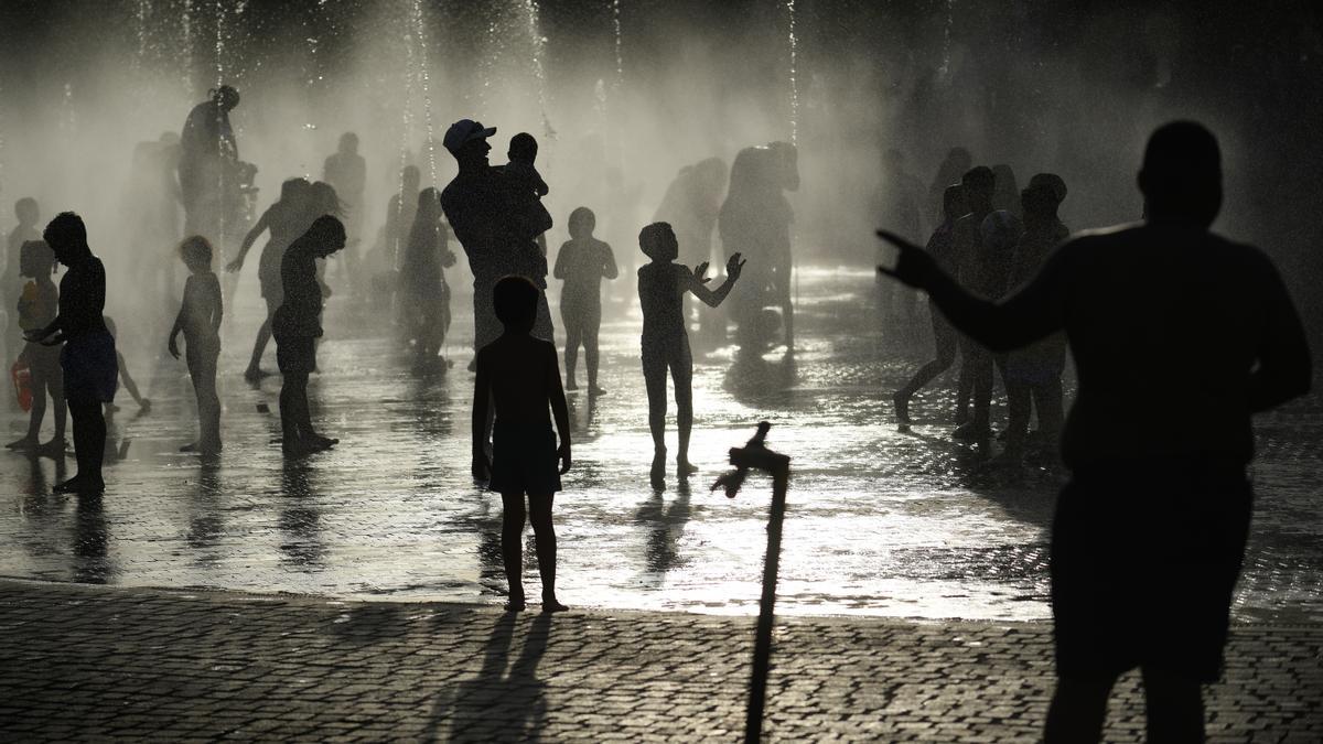 Grupos de personas disfrutan en la fuente transitable conocida popularmente como los chorros o la playa de Madrid Río, a 12 de junio de 2022, en Madrid (España). La llegada de la primera ola de calor del verano de 2022 ha puesto en riesgo a varias comunid