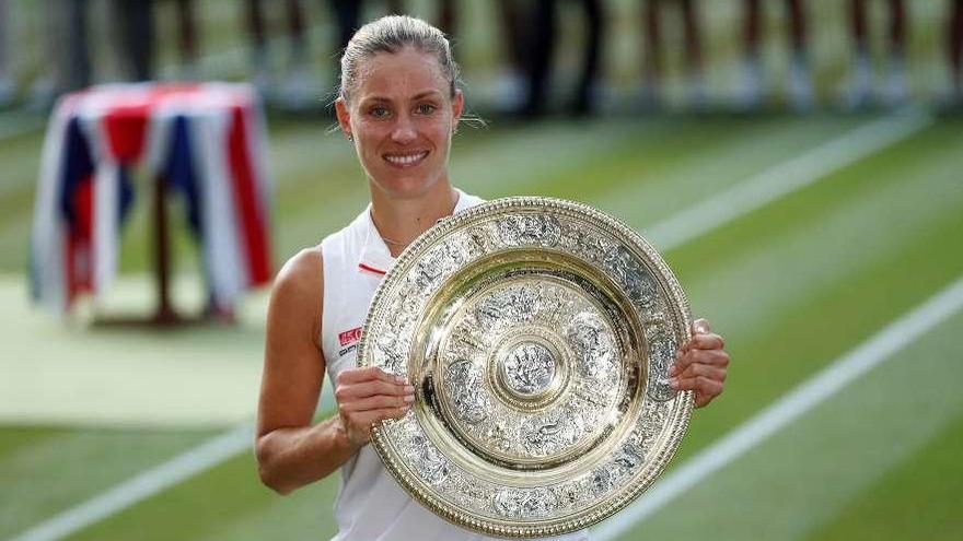 Kerber, tras recibir la bandeja que la acredita como campeona de Wimbledon. // Efe