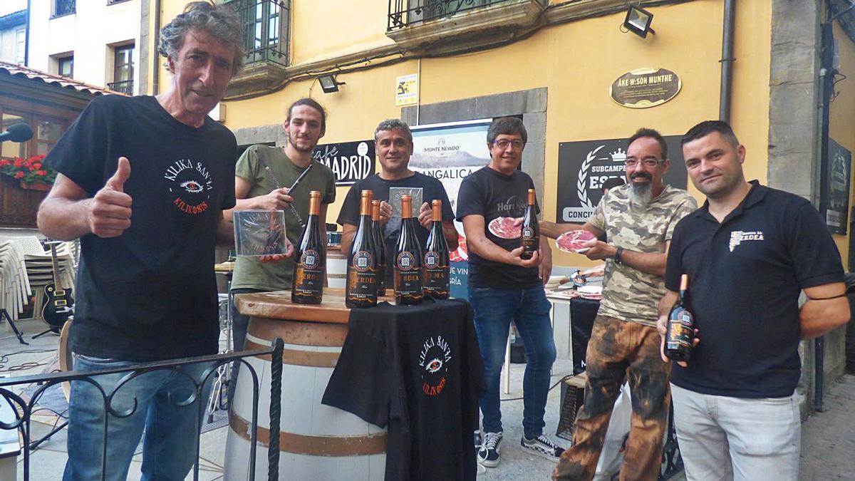 Por la izquierda, Guillermo Lastra, Juan Rodríguez, Manu Rico, Julio Santiago, David Mancebo y el bodeguero Luciano Gómez, con el disco y las botellas de vino, en Cangas del Narcea. | D. Á.