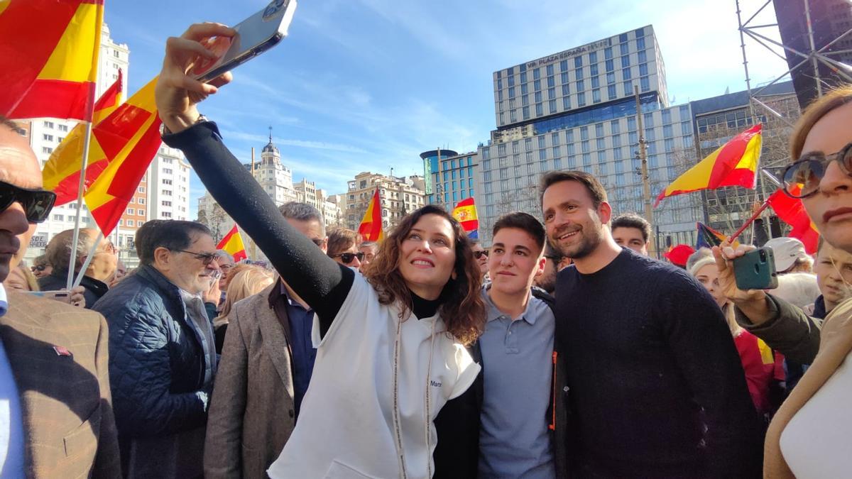 La presidenta madrileña, Isabel Díaz Ayuso, se hace un selfie con Álvaro Queipo y un militante.