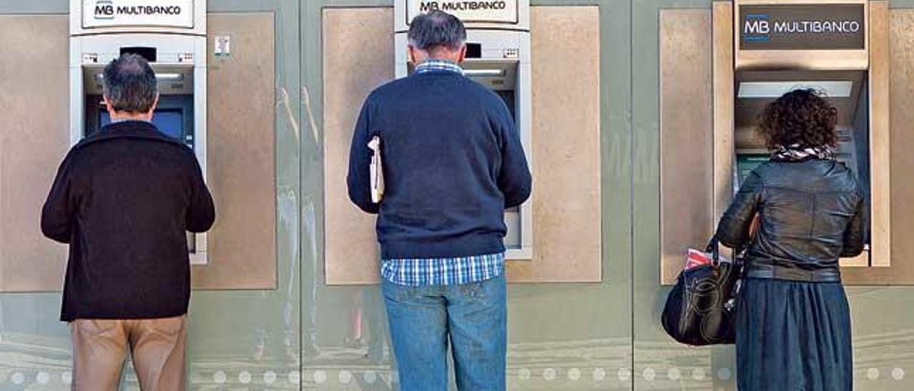 Personas sacando dinero de cajeros automáticos.