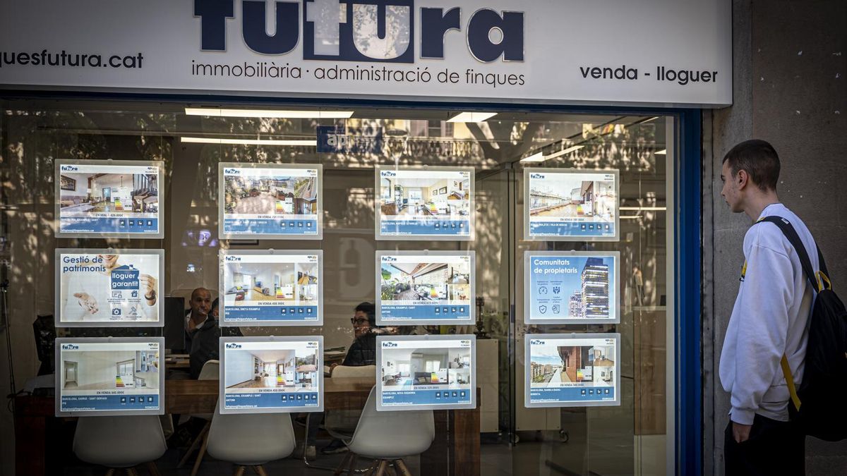 Imagen de archivo de un joven en el escaparate de una inmobiliaria
