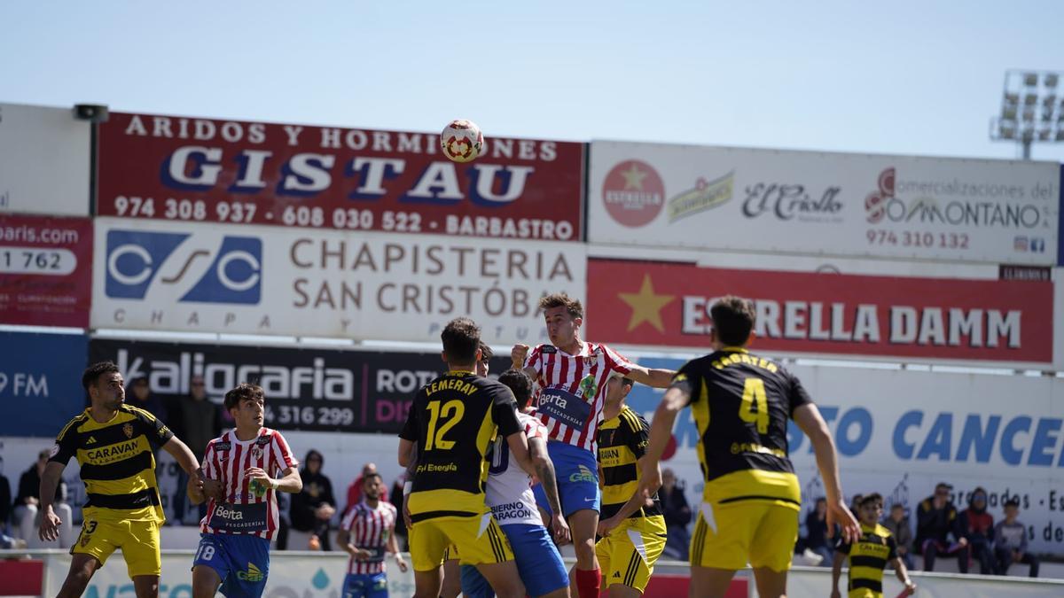 Duelo aéreo en un saque de esquina durante el derbi entre el Deportivo Aragón y Barbastro