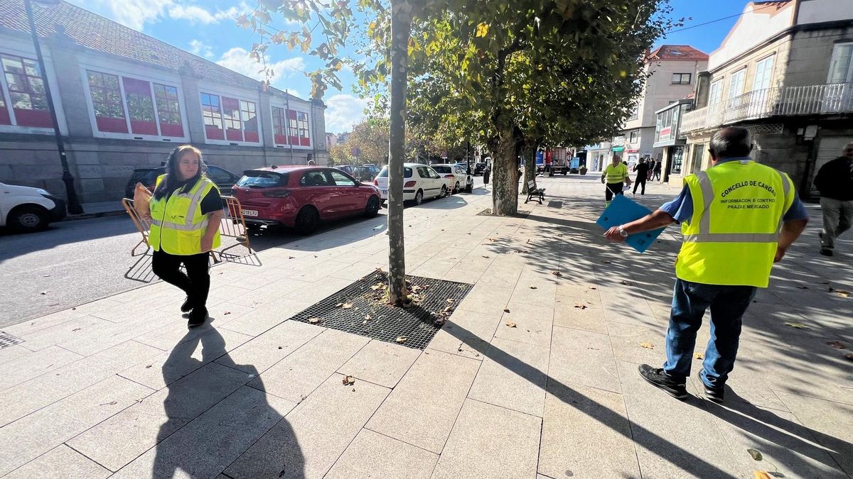Operarios municipales redistribuyendo espacios para los puestos en el entorno de la plaza de abastos, ayer.