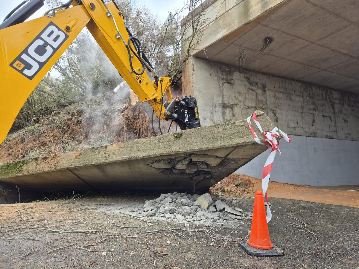 Una máquinia trabaja en la rotura de la aleta desprendida la pasada semana sobre el paso inferior.