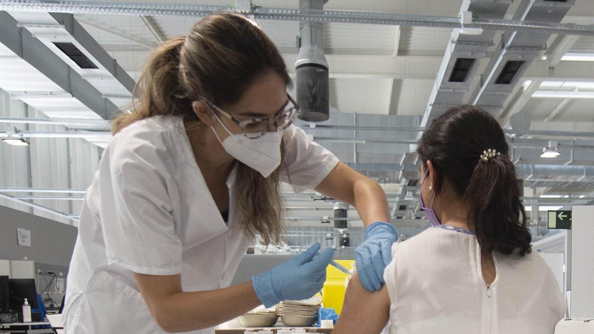 Una joven recibe la primera dosis de la vacuna Pfizer.