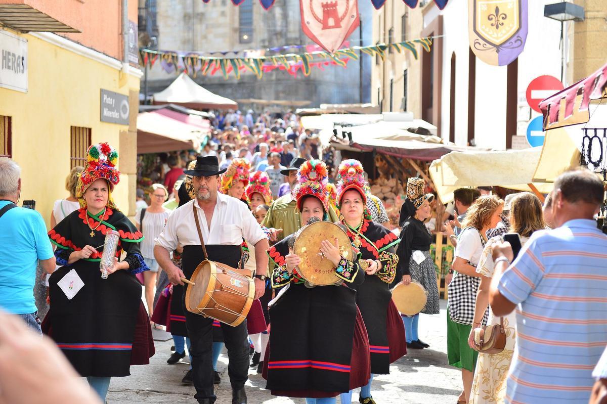Los tamborileros y los trajes tradicionales llenan de música y color el centro histórico de Plasencia en el Martes Mayor.