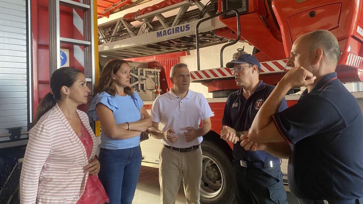 Águeda Fumero (i), Zaida González y Valentín González junto a bomberos del parque de Las Chafiras.