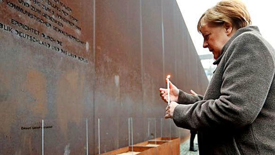 Merkel encén una espelma en memòria de les víctimes de l&#039;Alemanya dividida.