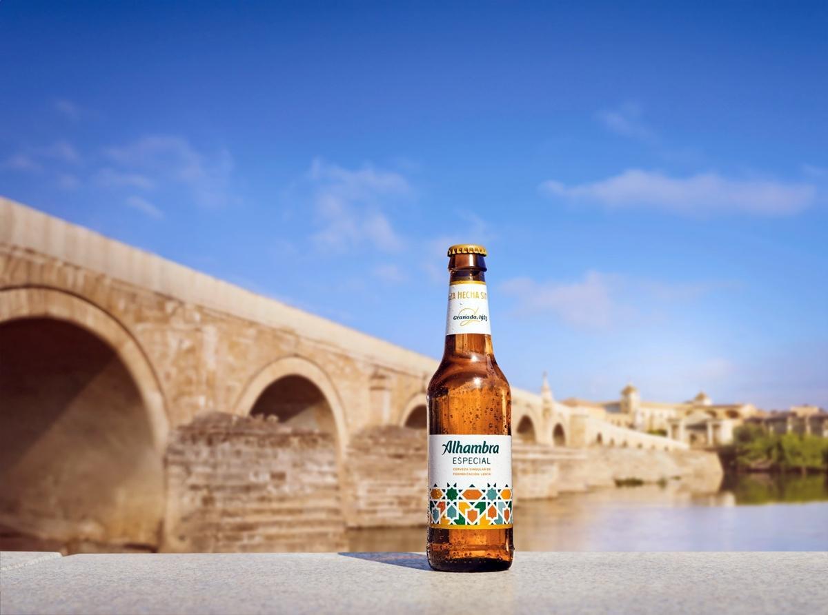 Cerveza Alhambra especial con el Puente Romano al fondo.