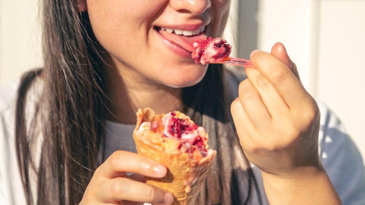 Una joven toma un helado despacito para que no le duela la cabeza.