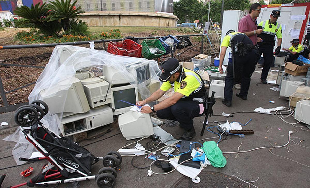La Guàrdia Urbana s’emporta els ordinadors dels manifestants acampats a la plaça de Catalunya.
