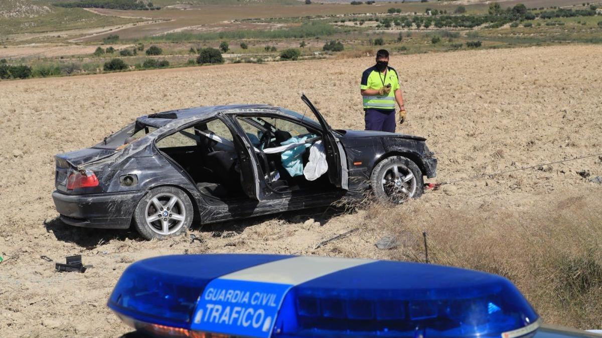 Un agente examina el vehículo accidentado.