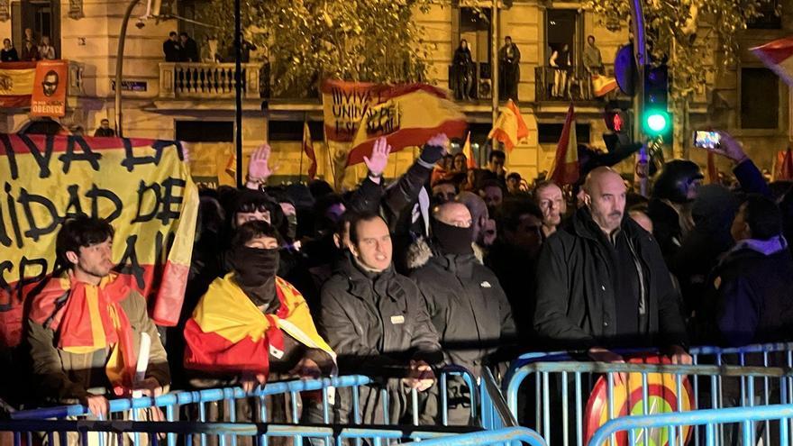 Persones amb la cara tapada i d'altres fent la salutació feixista amb el braç alçat durant la sisena nit consecutiva de concentracions a les immediacions de la seu del PSOE a Madrid per les negociacions de l'amnistia amb l'independentisme català