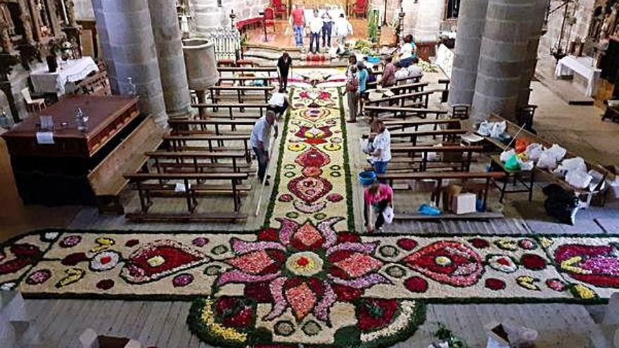 Los voluntariosos feligreses confeccionando la alfombra floral para la fiesta del Corpus, hoy en la iglesia de Bermillo.