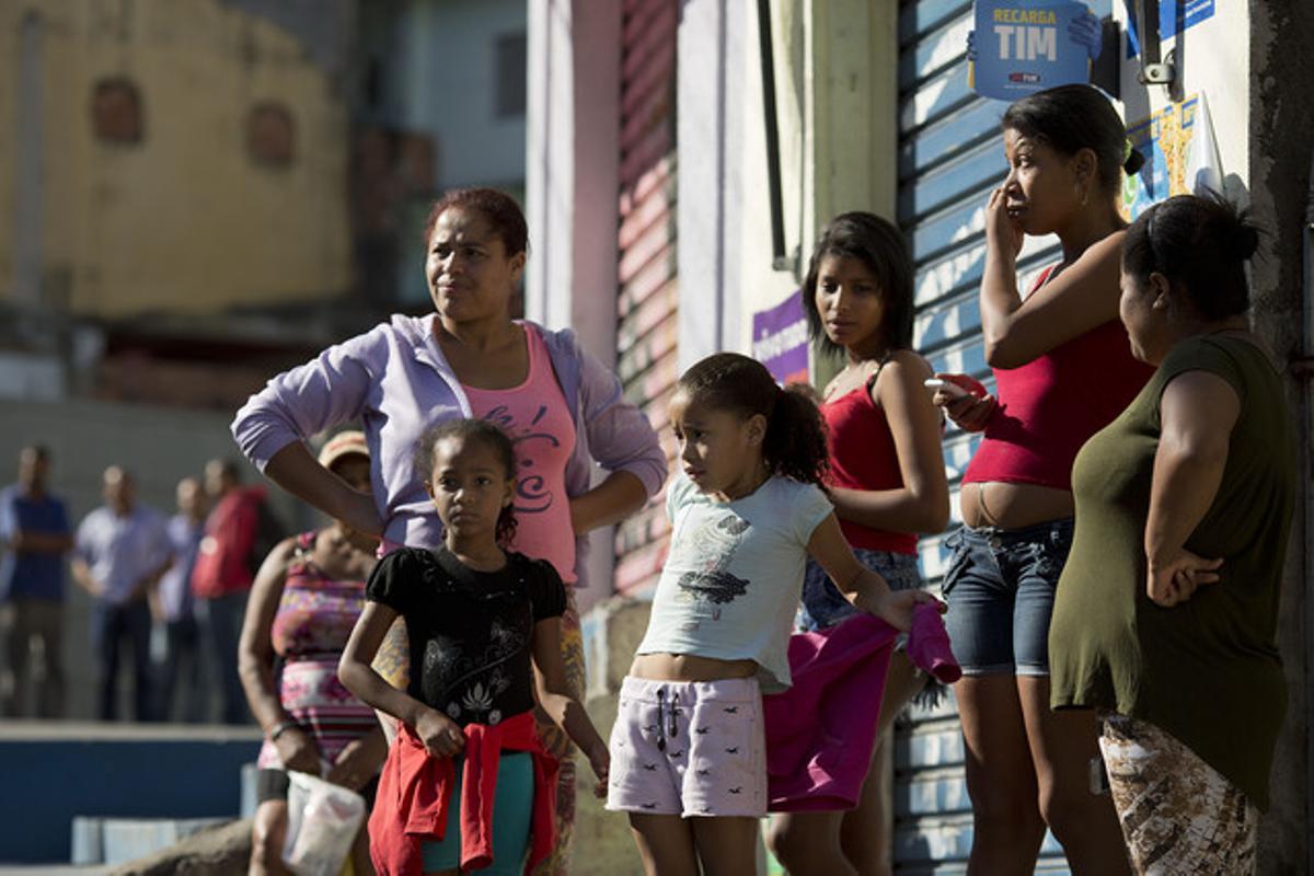 Residents en un carrer on durant la matinada del dissabte a diumenge han mort 10 persones a Osasco.