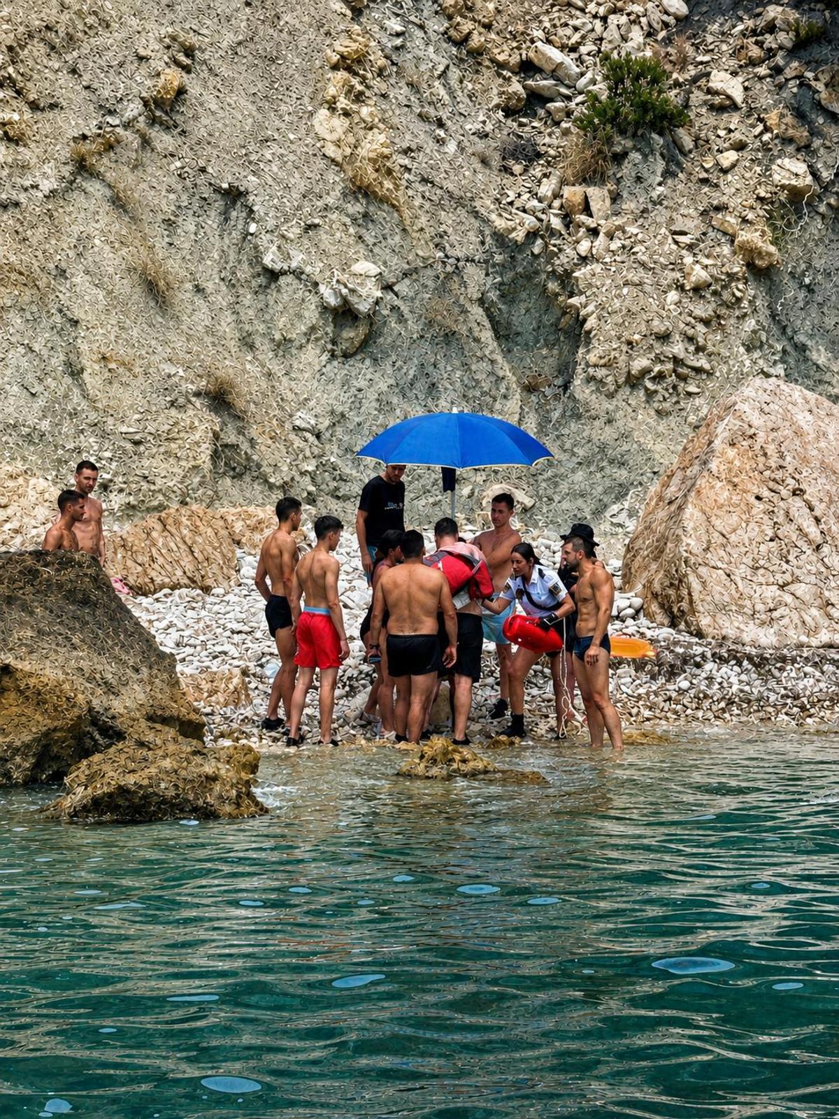 La agente que llegó a nado hasta la cala atiende a la chica que sufrió el desmayo