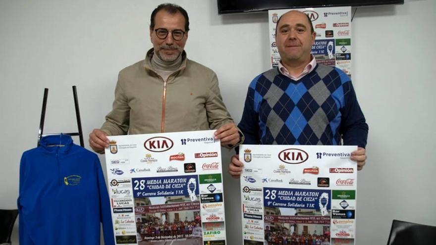 Antonio Moya y Joaquín Martínez, con el cartel anunciador de la carrera.