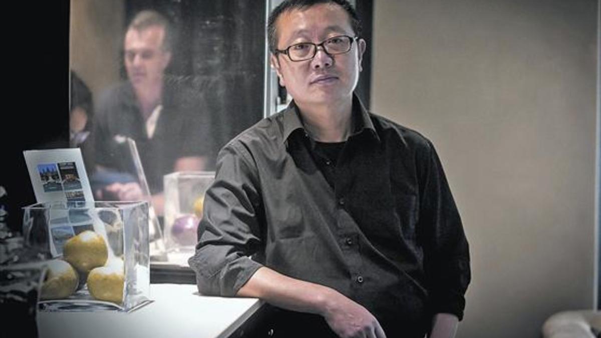 El escritor de ciencia ficción Liu Cixin posa en un céntrico hotel de Barcelona, el lunes. A la derecha, portada de 'El problema de los tres cuerpos' (Nova).