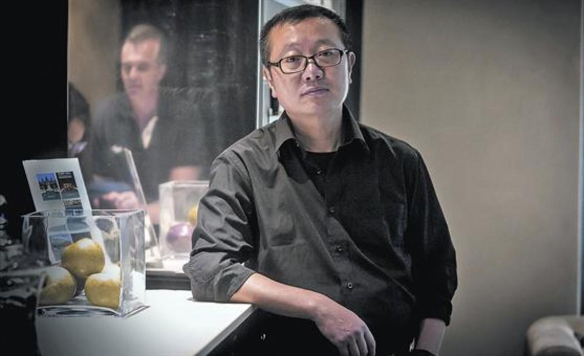 El escritor de ciencia ficción Liu Cixin posa en un céntrico hotel de Barcelona, el lunes. A la derecha, portada de 'El problema de los tres cuerpos' (Nova).