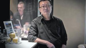 El escritor de ciencia ficción Liu Cixin posa en un céntrico hotel de Barcelona, el lunes. A la derecha, portada de ’El problema de los tres cuerpos’ (Nova).