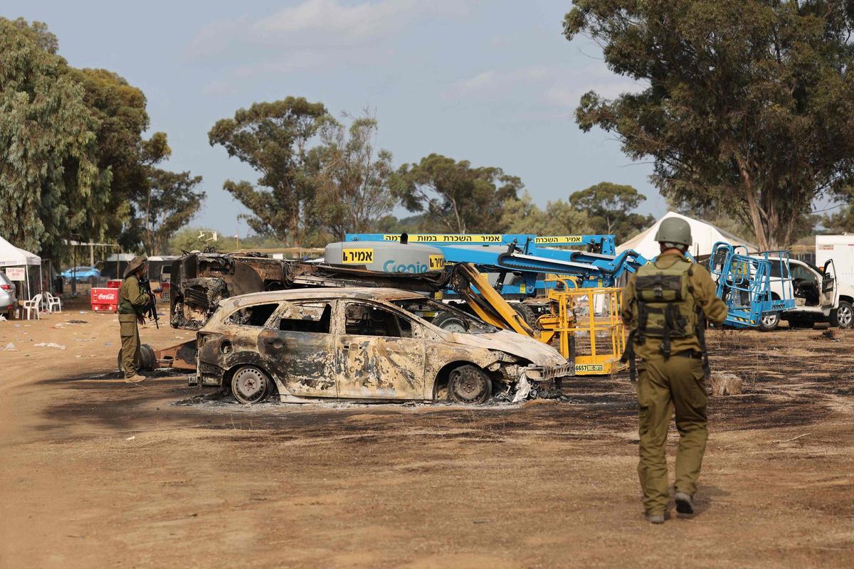 Las tropas israelíes inspeccionan el lugar devastado del ataque del fin de semana contra el festival de música del desierto Supernova por parte de militantes palestinos cerca del Kibbutz Reim en el desierto de Negev en el sur de Israel el 10 de octubre de 2023. Hombres armados de Hamas mataron a unos 270 juerguistas que asistían a un festival de música rave al aire libre en una comunidad israelí cerca de Gaza durante el fin de semana, dijo un voluntario que ayudó a recoger los cuerpos el 9 de octubre.