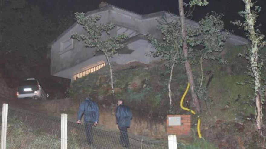 Dos agentes se dirigen a la casa en la que residía la víctima de 23 años, en la parroquia de Vincios, en Gondomar. / de arcos