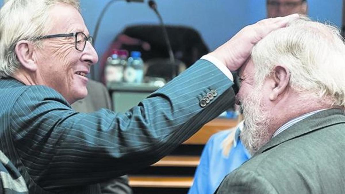 Juncker hace un gesto cariñoso hacia Cañete, ayer en Bruselas.